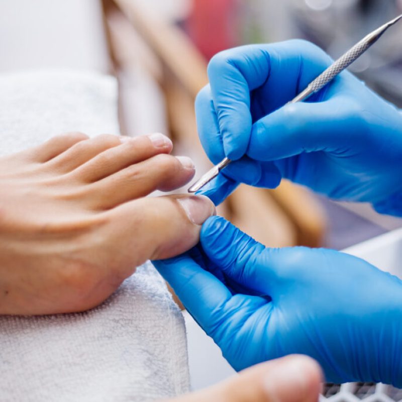 pedicure-process-home-salon-pedicure-foot-care-treatment-nail-process-professional-pedicures-master-blue-gloves-make-pedicure-1024x683